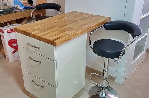 אי קטן במטבח עם מגירות אחסון ומשטח בוצ'ר אלון